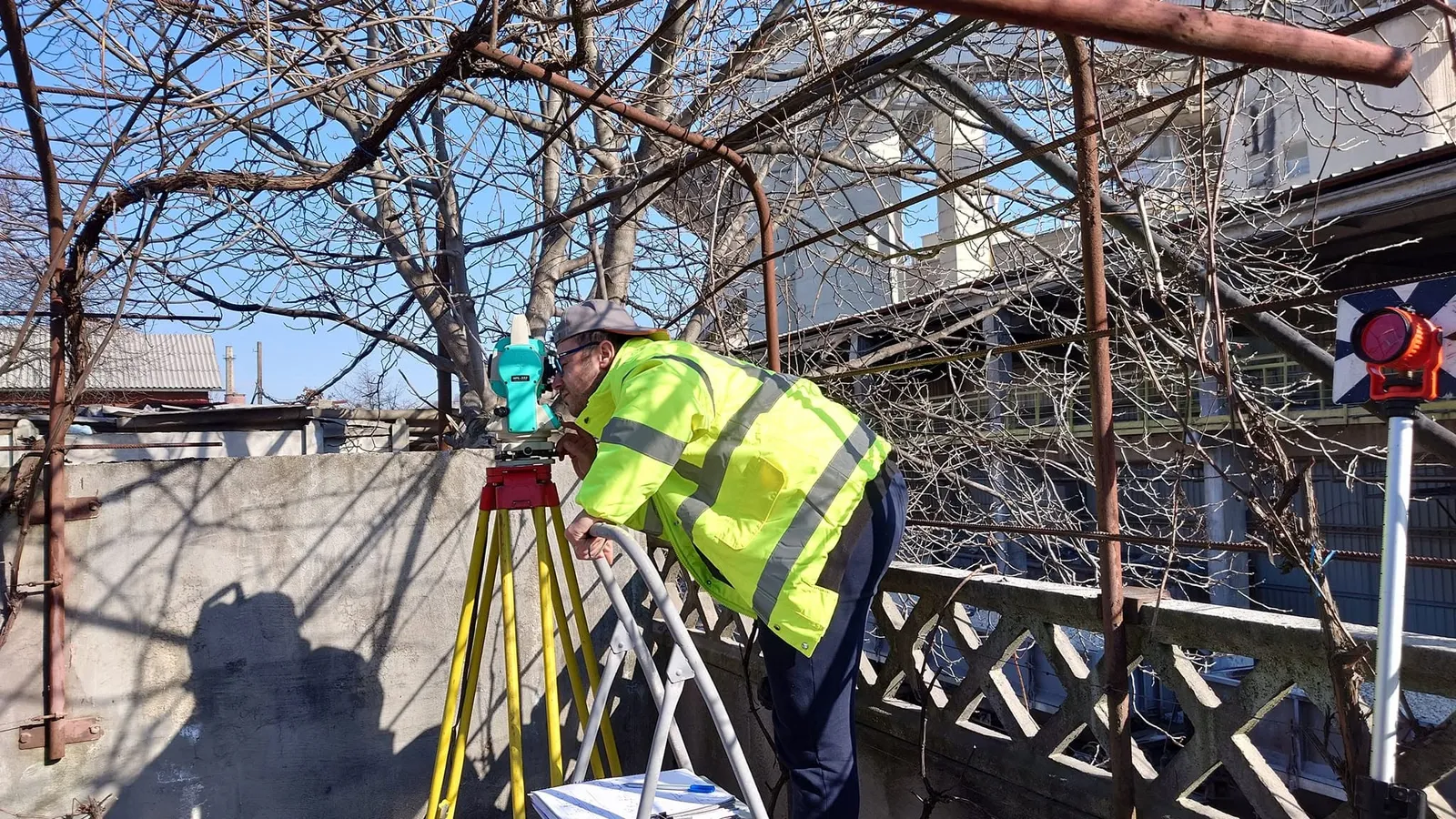 Inginer topograf vizând cu stația totală Nikon de pe o terasă